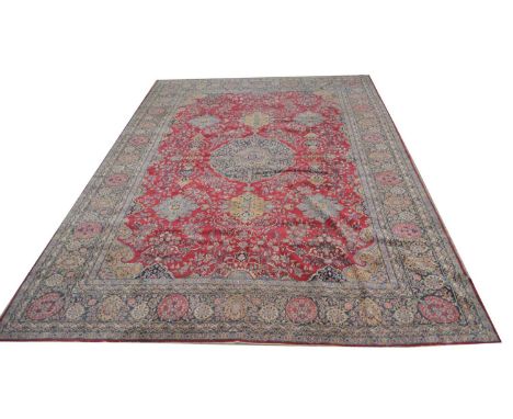 Lavar Kirman carpet, the central floral medallion surrounded by smaller medallions and scrolls on puce ground, 476 x 345cms.