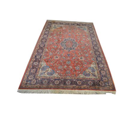 A Sarough carpet, the central floral medallion surrounded by foliate scrolls, on red ground, 351 x 273cms.