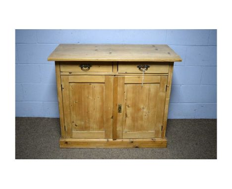 A Victorian-style pine side cabinet, the rectangular top above two short drawers, a pair of panelled doors below opening to r