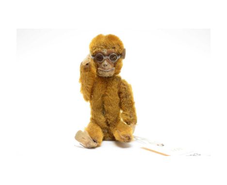 A vintage tricky monkey teddy bear, modelled wearing glasses, with swivel head, possibly by Schuco.