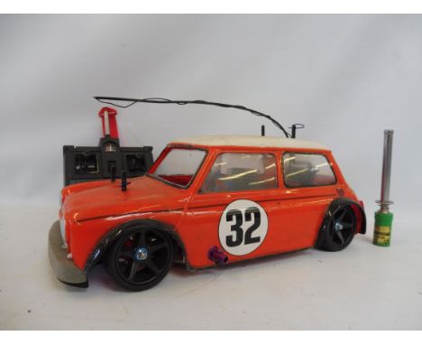 A Tamiya Mk. I Mini Cooper 2003 racing car fitted with a nitro engine complete with a rip max Futaba controller and a globe p