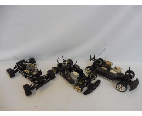 Three Nitro RC chassis': a Kyosho 4WD Alloy fitted with a nitro engine, a Kyosho 4WD Alloy fitted with a G12 nitro engine and