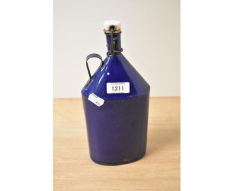 A vintage blue enamel flask with stopper and handle.