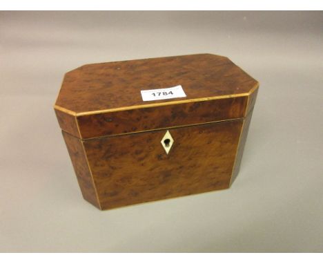 George III burr yew and boxwood strung tea caddy of irregular octagonal design, the hinged cover enclosing a two division int