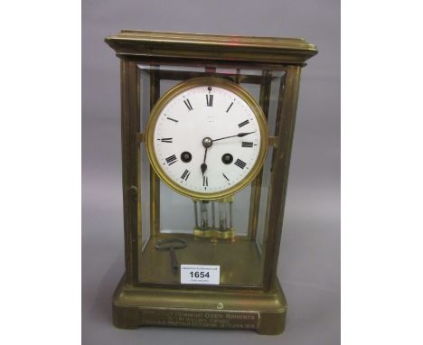 Late 19th / early 20th Century brass four glass library clock having circular enamel dial with Roman numerals and two train m