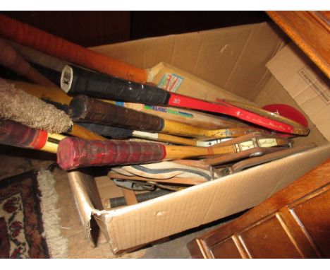 Box containing a quantity of various vintage tennis rackets, cricket bats, hockey sticks etc. 