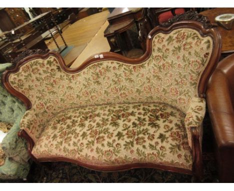 19th Century carved mahogany double chair back sofa, the shaped moulded and floral carved back above an overstuffed seat and 