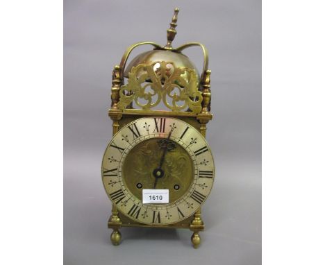 Early 20th Century brass lantern clock with a floral engraved dial, silvered chapter ring, Roman numerals and two train movem