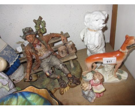 Staffordshire figure of a dog holding a rabbit, bisque porcelain figure of a dog, Naples figure of a seated tramp on a bench 