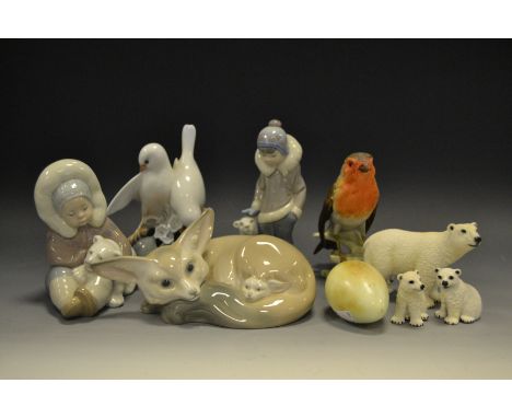 A Llado model of a Fennec Fox & Cub, boxed; a Lladro model of a sitting Inuit holding a  Polar Bear cub, boxed; another stand