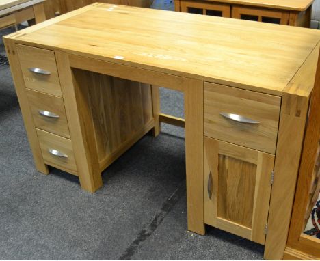 A contemporary light oak knee hole desk