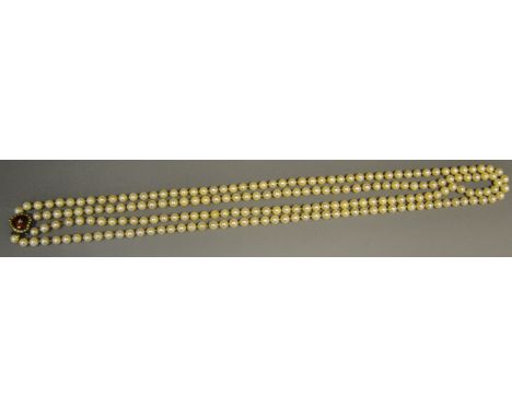 A Victorian two strand cultured pearl (7mm) necklace, a white metal heart shaped fastener, white stone surround, red enamel c