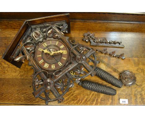 A 19th century Black Forest cuckoo clock, profusely carved throughout, with pine cone cast weights