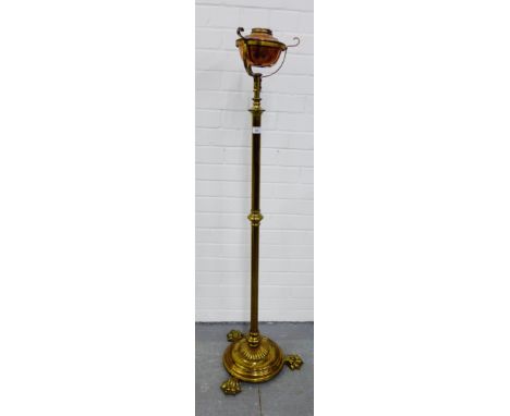 A brass standard lamp, the circular base with three hairy paw feet, 133 high, excluding light fitting