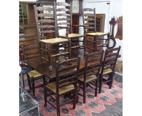 An Antique oak draw leaf dining table, raised on heavy carved baluster legs, together with a set of 9 oak and rush-seated lad