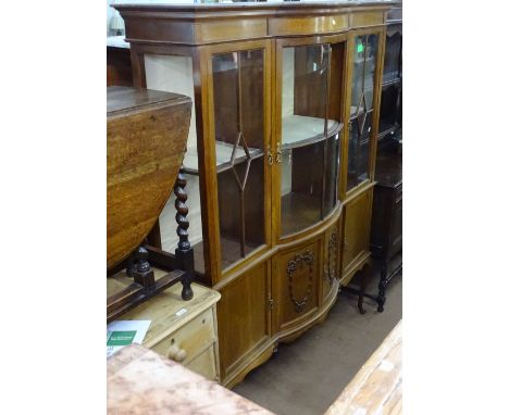 An Edwardian mahogany bow-front display cabinet, with lattice glazed doors above panelled cupboards, raised on cabriole legs,