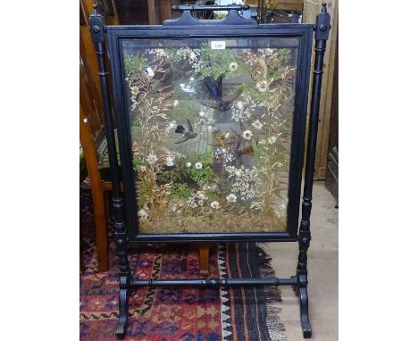 A Victorian ebonised firescreen, the glass panel depicting a display of taxidermic birds, butterfly and dried flowers, W65cm 