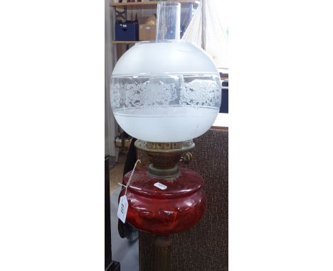 An Antique brass oil lamp with cranberry glass font, height 27.5" 