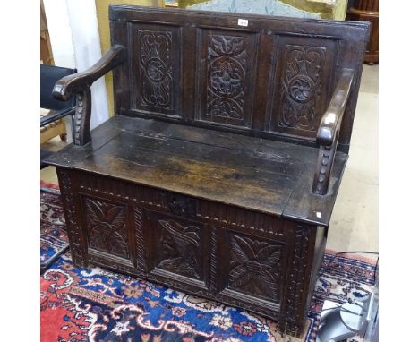 An Antique panelled oak hall bench, with rising seat and chip carved panels, on stile legs, W105cm 