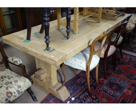 A large light oak plank-top dining table, raised on tablet ends, L220cm, with 2 additional spare leaves extending to L320cm, 