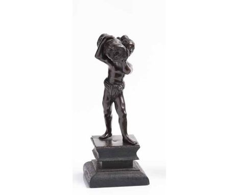 BRONZE FIGURE MODELLED AS AN ETHNIC MANcarrying a log on his shoulder, unsigned, over a stepped ebonised wooden base, 21cm hi