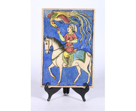 20th century painted Qajar style tile depicting a figure on horseback feeding a peach to a phoenix, 30cm x 20cm. 