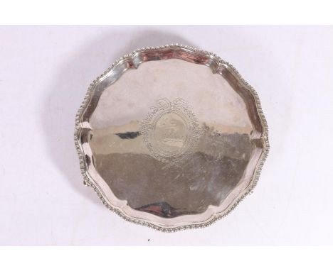 George III silver salver with pie-crust edge having feathered border, with central lion within wreath crest, maker's mark 'RR