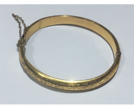 9ct yellow gold half engraved bangle 9.1g. A few dents/bashes.  Closure very stiff.  58mm inner diameter.