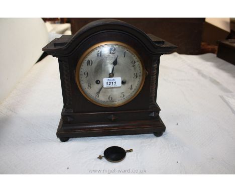 A circa 1920 Oak cased architectural  Mantle Clock, having moulded arched top over circular brass trimmed glass door to the a