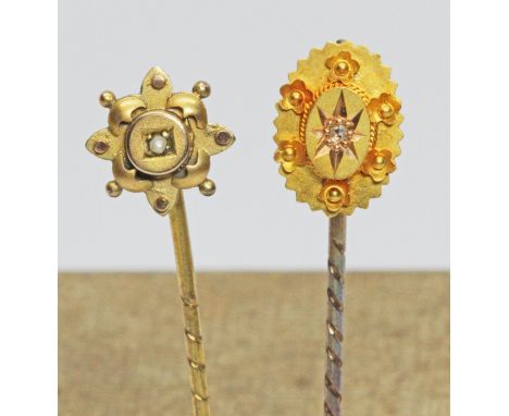 Two antique stick pins; one set with a diamond and marked '18ct', the other set with a seed pearl and marked '9ct'.  