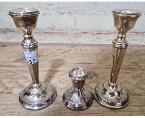 A pair of silver candlesticks, Birmingham, AT Cannon Ltd, 1969 together with another candlestick.