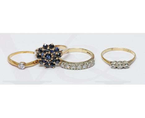 A group of four rings comprising three 9ct gold and one three stone diamond ring indistinctly marked, gross weight 9.2g.  