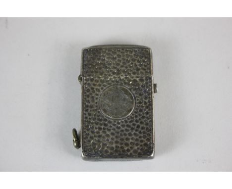 A white metal cased cigarette lighter with beaten design around central monogram, stamped Hallmarked Silver to base and maker