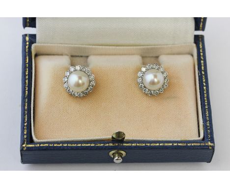 A pair of cultured pearl and diamond ear studs, the single pearl in a border of fourteen  brilliant cut diamonds in Mappin & 