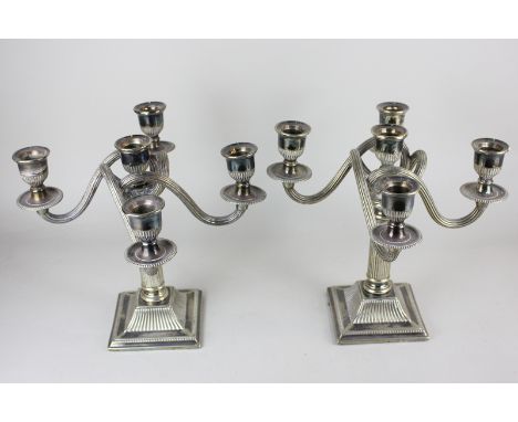 A pair of silver plated five light candelabra, on reeded stems and square bases, 26cm high