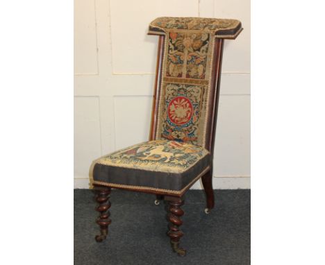 A Victorian mahogany framed prie-dieu chair, with tapestry upholstered back and seat, on barley twist front legs and castors