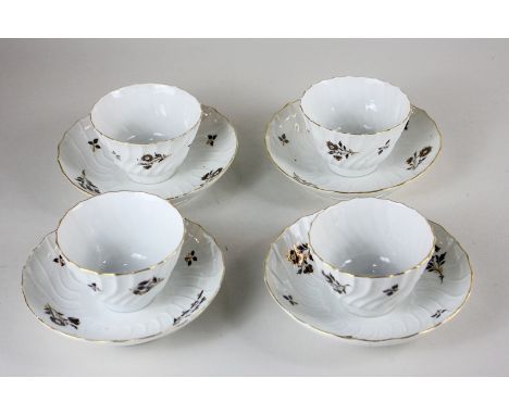 A set of four late 18th/early 19th century porcelain tea bowls and saucers with scalloped form and brown and gilt floral desi