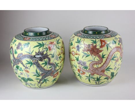 A pair of Chinese porcelain ginger jars (missing covers) depicting dragons chasing the flaming pearl, on yellow ground, Kangx