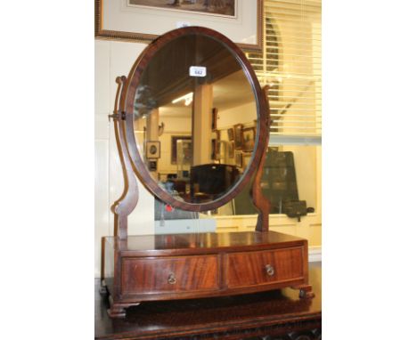 An oval mahogany dressing table mirror on bow fronted box base with two drawers, on bracket feet, 45cm