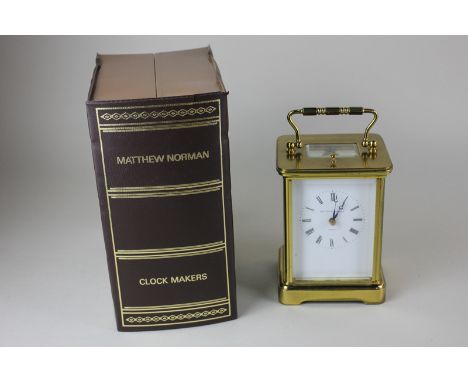 A Matthew Norman brass and bevelled glass cased carriage clock, the white enamel dial with Roman numerals, marked London, the