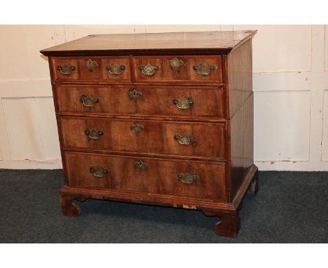 A George II cross-banded walnut chest of two short over three graduated drawers, with feather banding, on bracket feet, 97cm