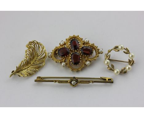 A garnet and pearl brooch in 9ct gold, a 9ct gold fern brooch, a pearl circlet brooch and a pearl bar brooch