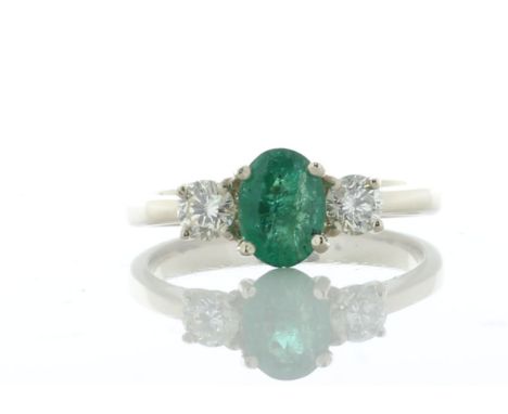 A dazzling green oval emerald weighing 0.73 carats is set between two round brilliant cut diamonds. This stunning 18ct yellow