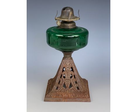 A Victorian oil lamp, having an emerald glass reservoir and cast pyramidal base