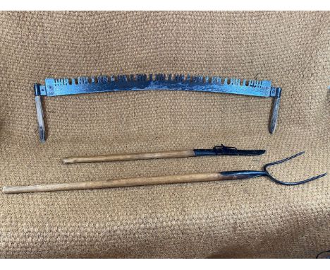 An antique pitch fork, a hedge knife and saw