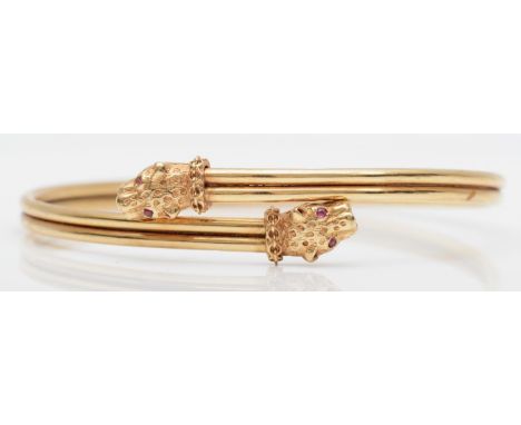 A vintage 9ct gold sprung bangle, Birmingham 1989, with leopards head terminals, ruby set eyes, 9.6gmExternal circumference i