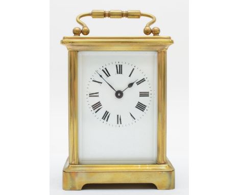 A brass eight day carriage clock, having enamelled dial with Roman numerals, with travel case and key. 12cm tall. 