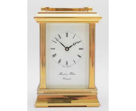 An English brass carriage clock, the enamelled dial with Roman numerals, having eight day jewelled movement. 13cm tall. 