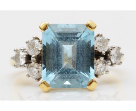 An 18ct gold aquamarine and diamond dress ring, claw set with a step cut stone, 11 x 9mm, brilliant cut diamond trefoil shoul