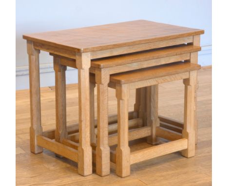 Robert 'Mouseman' Thompson, an oak nest of three tables, having adzed rectangular tops, on four octagonal legs, joined by rai